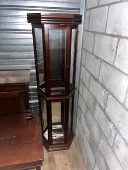 Curio cabinet with multiple glass shelves, wood frame.
