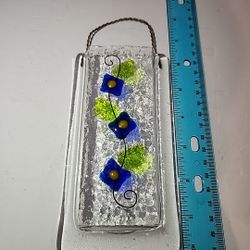 Doug Latta's fused glass hanging pocket vase with a blue flower and green leaf design