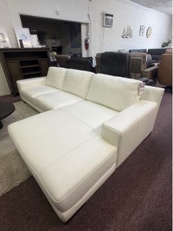 Estimated: (WxDxH): 112 x 63 x 32 in  Retail price:$6,600  Modern two-piece sectional sofa with chaise has a white leather upholstery. It features sim