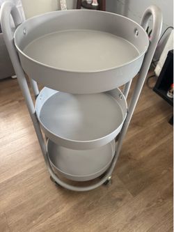 Gray three shelves of round metal with wheels