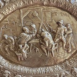 Vintage oval embossed brass decorated with tavern scenes, bordered by a very ornate frieze. Lots of details. Very decorative, pretty patina. 