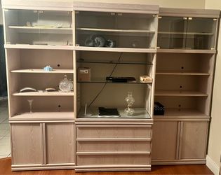 3 piece Light-colored wooden display cabinet with glass doors.