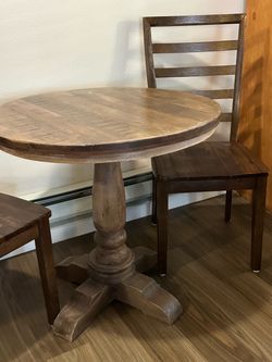 World Market Pedestal Wood Table and two wood ladder back chairs