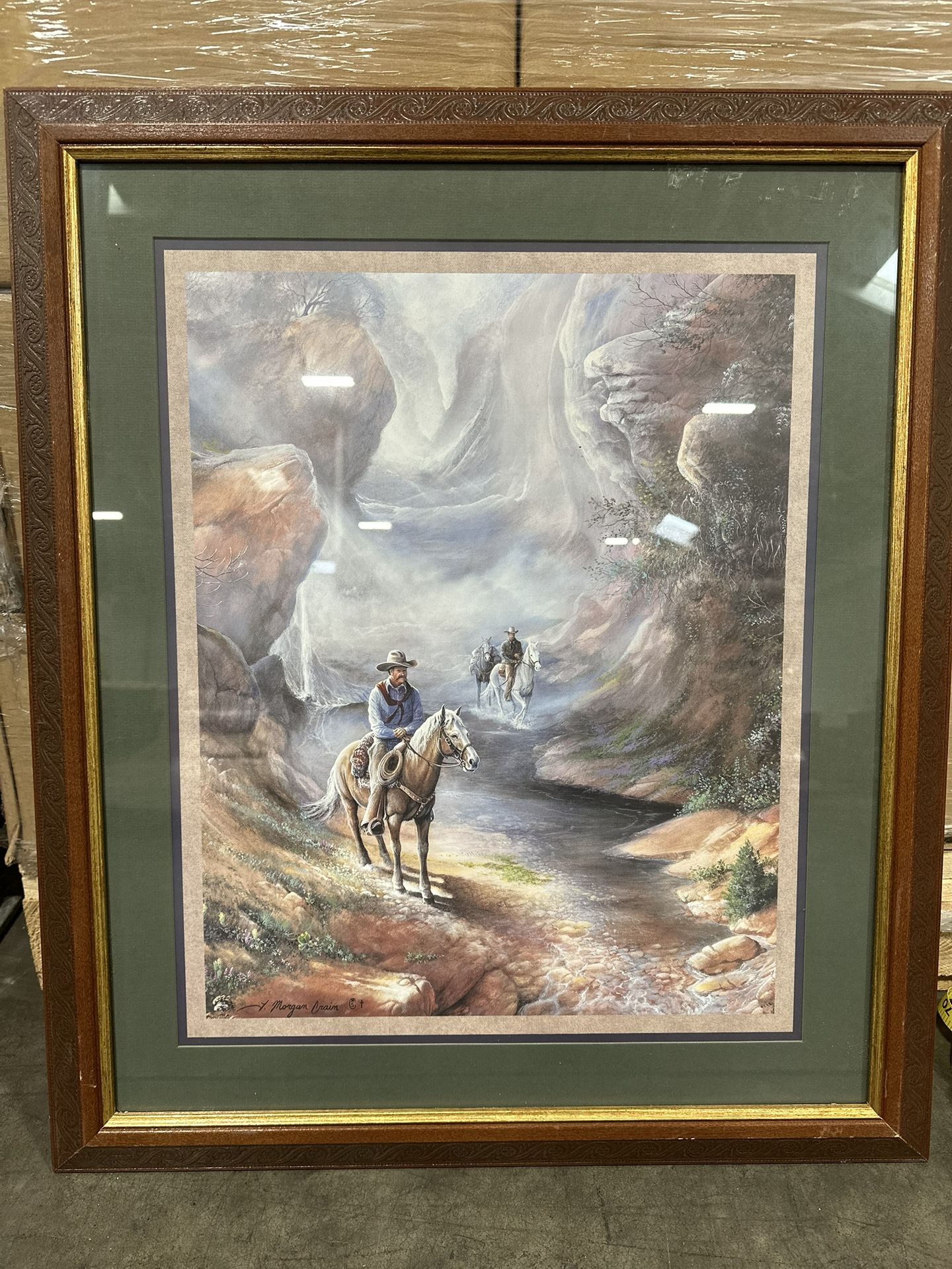 Beautiful framed print of a western scene with cowboys on horseback. Signed by J. Morgan Crain. Brown wooden frame with green mat and gold border. Beh