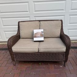 Patio furniture: Very sturdy wicker sofa with washable cushions and brand new cover
