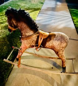 This vintage rocking horse features a mohair-covered body and a distinctive black mane