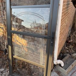 Storm door with glass and roll down screen.