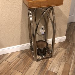  Tall decorative accent table featuring a sleek, arched metal base and a wooden top