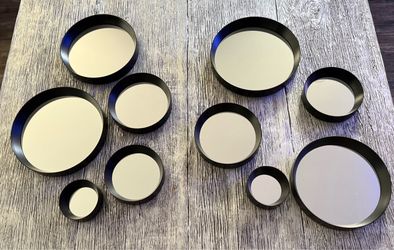Set of 10 decorative round wall mirrors in assorted sizes.