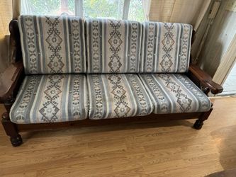 Vintage Dark Solid Wood Couch With Three Navajo Pattern Cushions.
