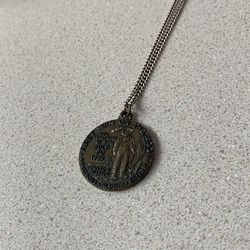 vintage Apollo 11 Moon Mission commemorative medallion or pendant, often sold as a souvenir following the historic landing on July 20, 1969.