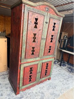 This Mexican hand-carved armoire features a rustic design
