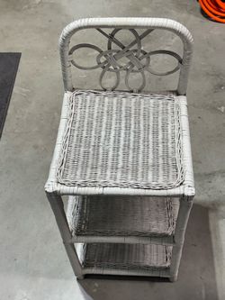 vintage white wicker three-tier shelf featuring a knotted, heart-like design on the top backrest. 27” x 12” x 12”