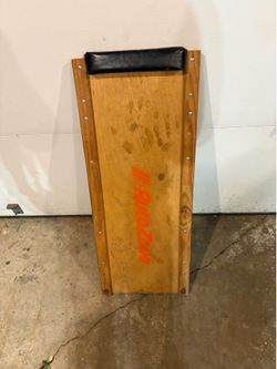 vintage wood AutoZone mechanic's creeper with a padded headrest