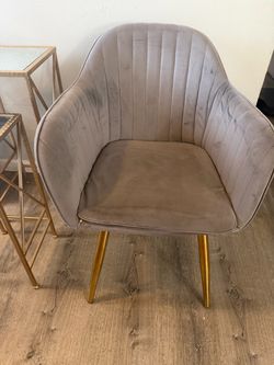 modern gray velvet upholstered accent/dining armchair with vertical tufted channel back detailing and tapered gold-finish metal legs