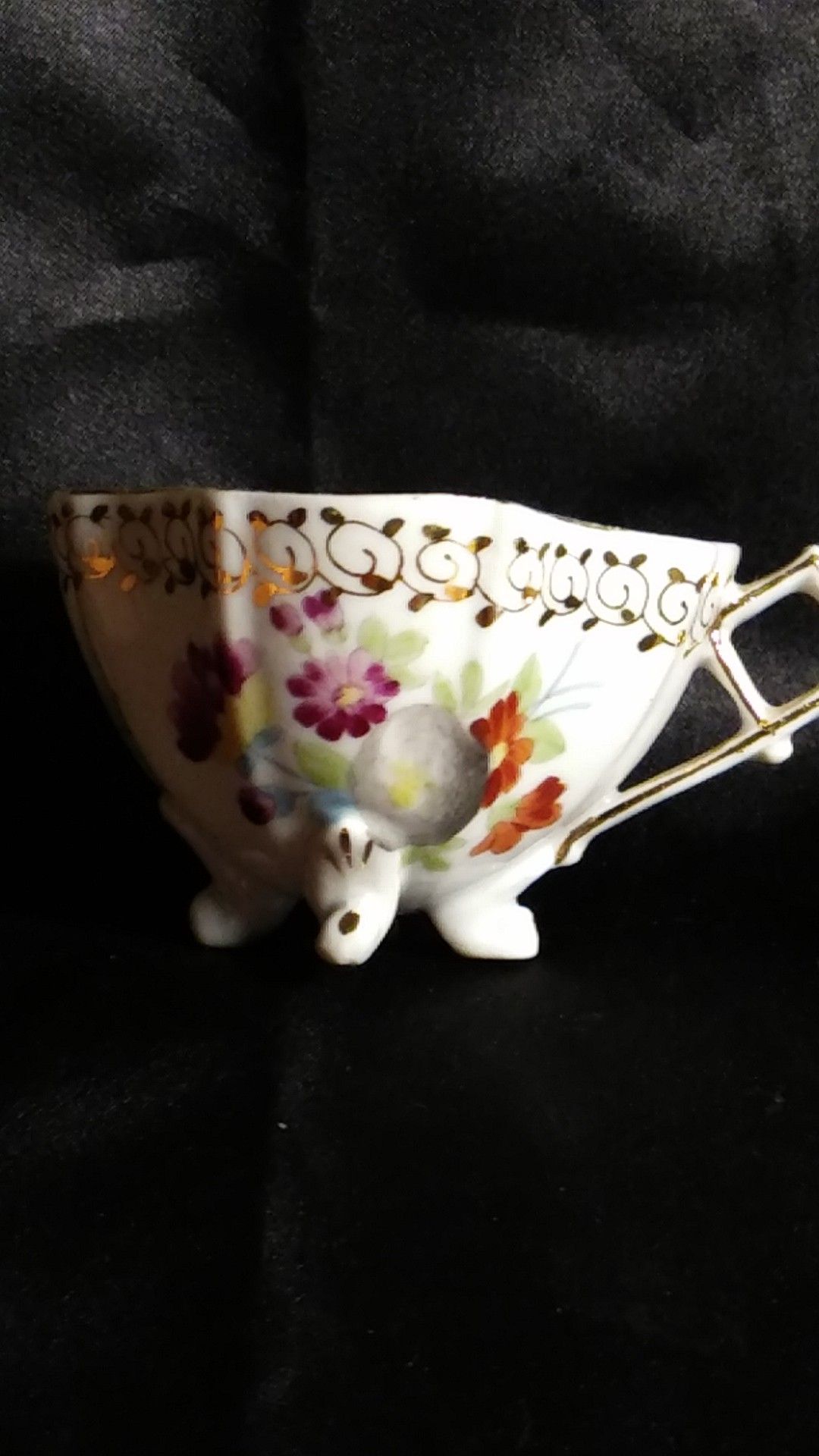 Miniature Porcelain Tea Cup. Four Footed Hand Painted Gold Trim