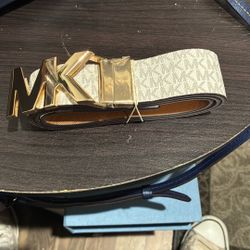 Michael Kors Reversible Signature Belt featuring a gold-tone "MK" logo buckle. [1, 2, 3]    AI responses may include mistakes.  [1] h