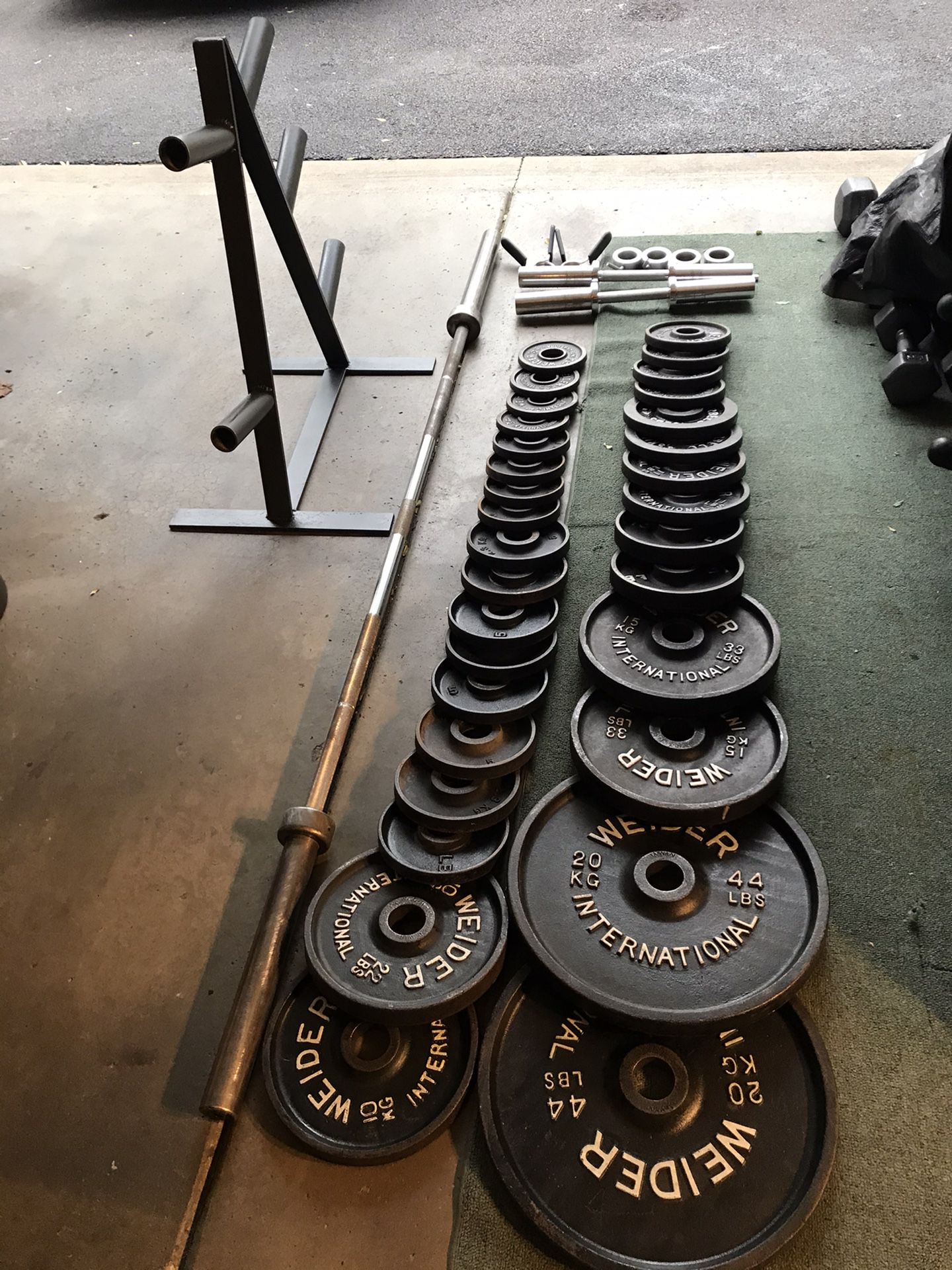 385lb Olympic weight set, 7ft 45lb Olympic bar, 2 Olympic dumbbells,& olympic plate tree $275