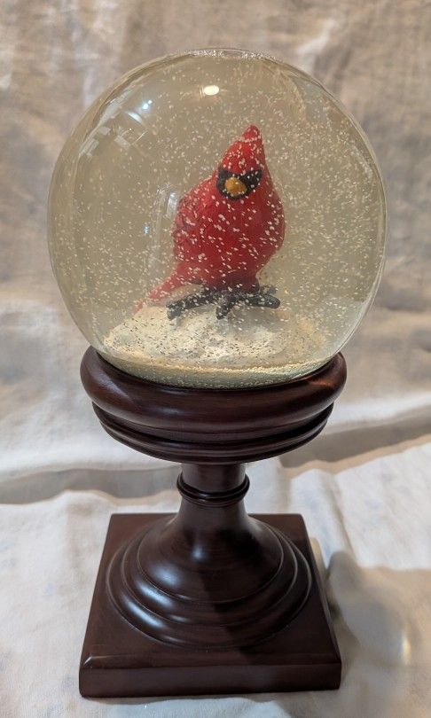 Holiday Cardinal Snow Globe With Brown Base.
