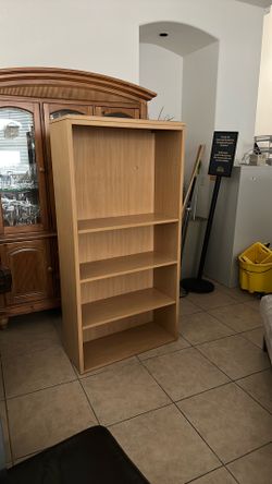 Bookshelf has additional shelf with holders