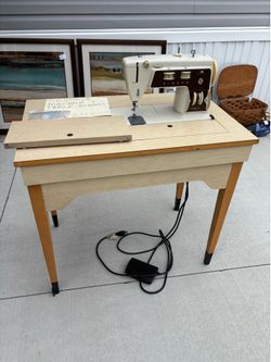 $20  cabinet, singer sewing machine that closes into a table also with bobbins