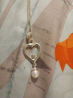 Pearl hanging from a silver heart