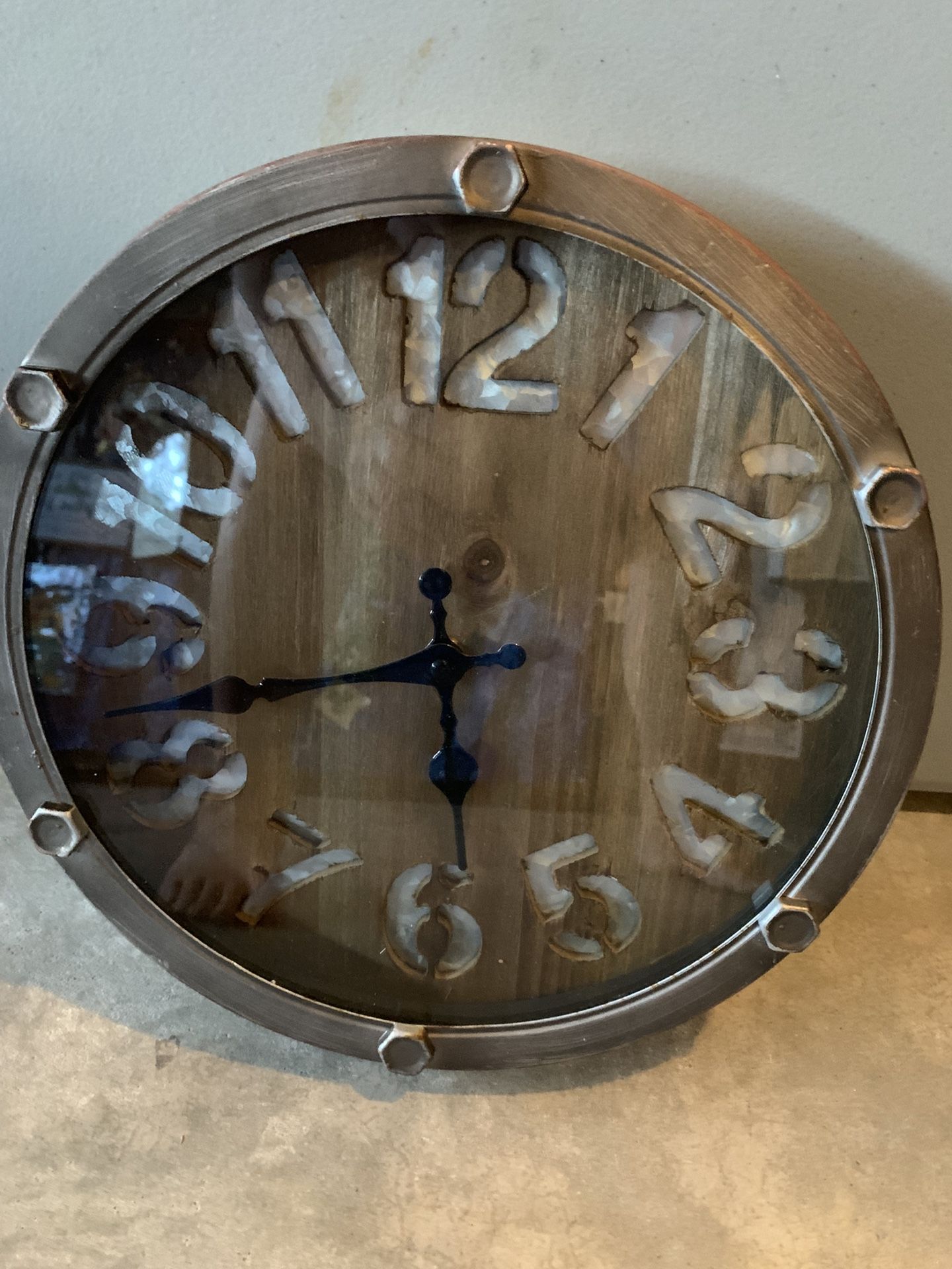 12 Inch Round Galvanized Metal Clock, Wood Background W/ Number Cut Out, Bolts, Aged Finish, Glass Face, Hanging Hook
