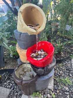 Water flows sequentially from the top pot down through the middle layers.