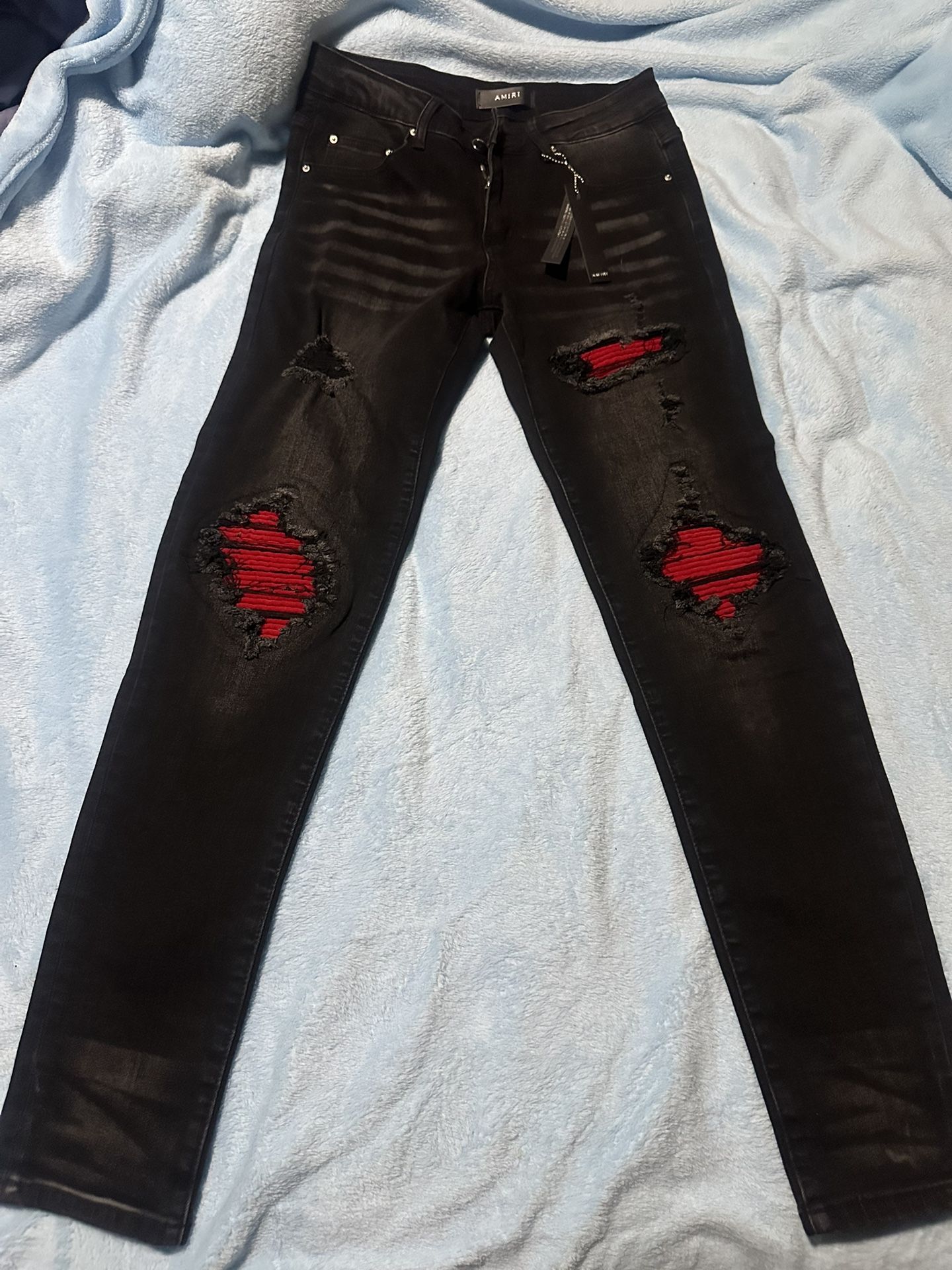 black amiri jeans with red patches