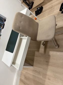 Beige Upholstered Rolling office Chair and white office desk