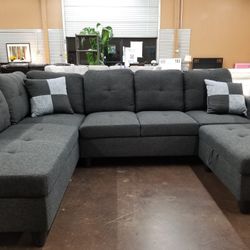 Charcoal gray fabric sectional with a matching storage ottoman