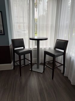 Two sets of high top bistro tables