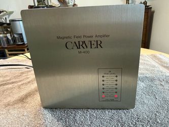 Powerful Carver M-400 magnetic field power amplifier has a brushed silver metal chassis. This unit is a stereo power amplifier with a peak level LED d