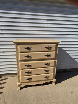 Solid wood 5-drawer chest by Fairmont Designs 

(sold new for $1,679). 

Cream/oyster finish, ornate black pulls, carved feet, dovetail drawers that s