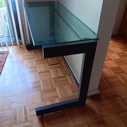 Modern glass top desk with metal frame.