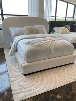 New King size white fabric upholstered platform bed.