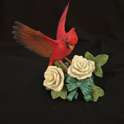 A Lenox porcelain figurine of a cardinal with white roses and a ribbon.