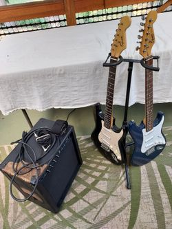 Two Fender electric guitars an Amp and a stand fender strat and fender bullet