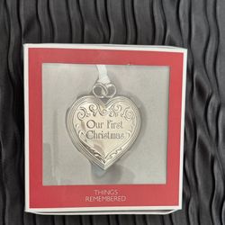 heart-shaped, silver-tone ornament features a locket design
