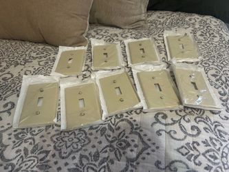 9 pack box of Ivory plastic wall plates