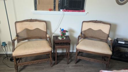 2 antique Louis XV style armchairs feature walnut frames with intricate cane detailing on the seats and backs.