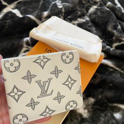White Louis Vuitton wallet with monogram design.