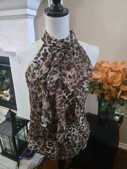 The Byer California summer top in tan, brown, black, and white leopard print is a stylish and versatile option for the warmer seasons. This sleeveless