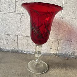Striking vintage red art glass vase with clear pedestal stem. A bold decorative accent.