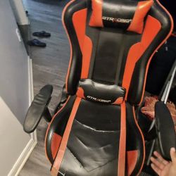 Worn down gaming chair with footrest and speakers
