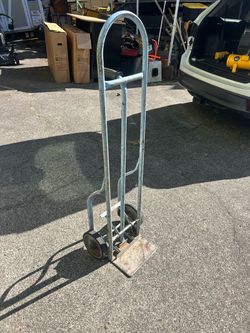 Vintage hand truck that has a foot pedal that pushes the cargo off of the plate of the handtruck. Good for box moving especially. Other items can be m