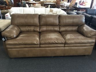 Brown leather couch by Simmonds furniture, brand new but has a slight tear on the back