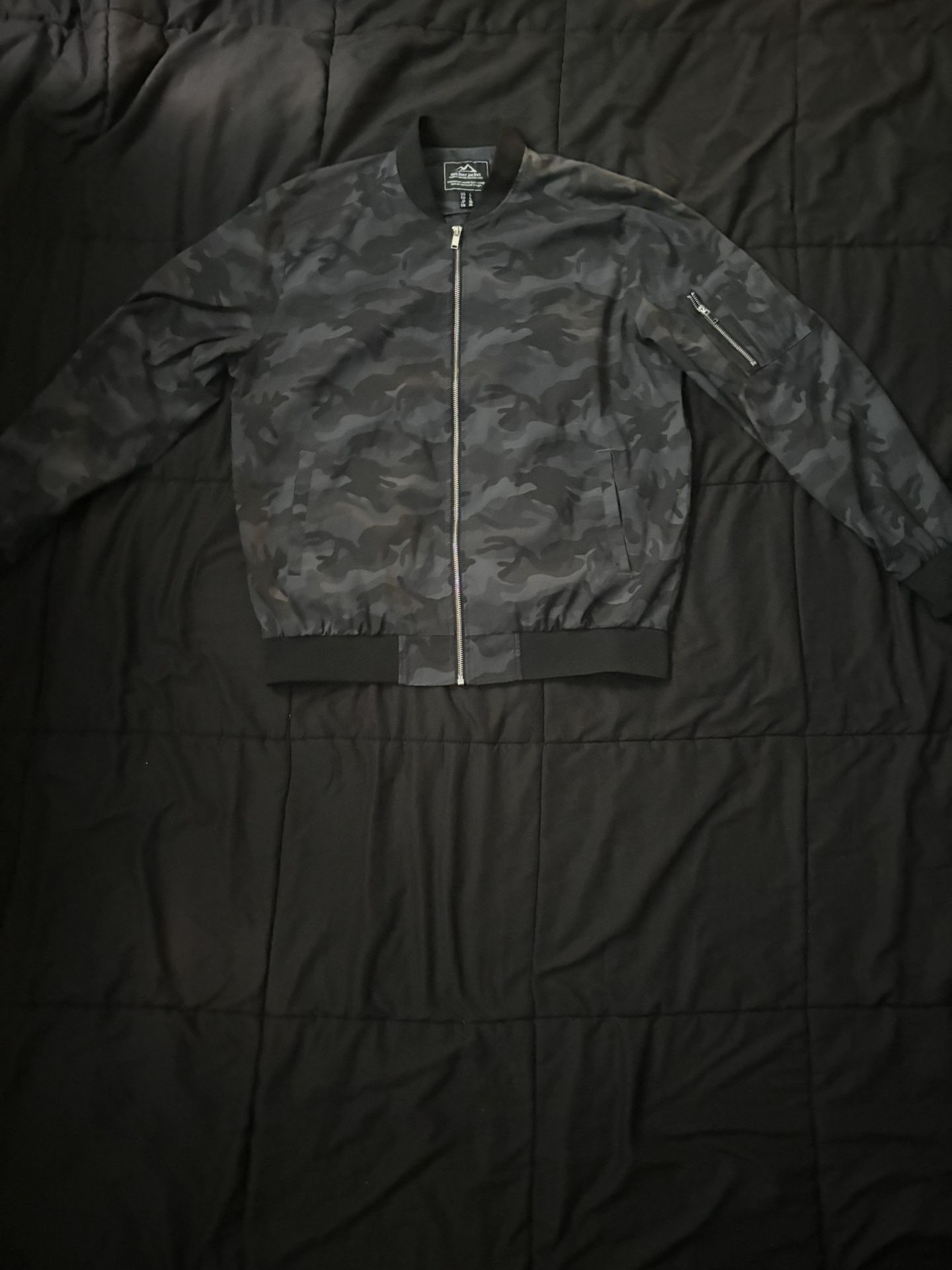 camouflage bomber jacket with a metal zipper.