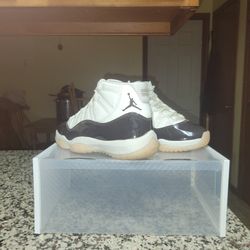 Jordan 11 Retro 'Neapolitan' basketball sneaker featuring a white upper and a glossy Velvet Brown patent leather mudguard. 