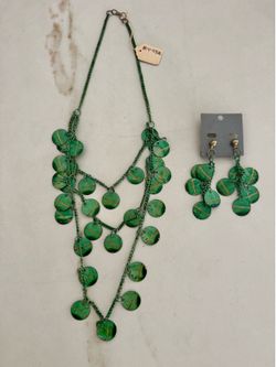 A three-strand green coin statement necklace and earrings.